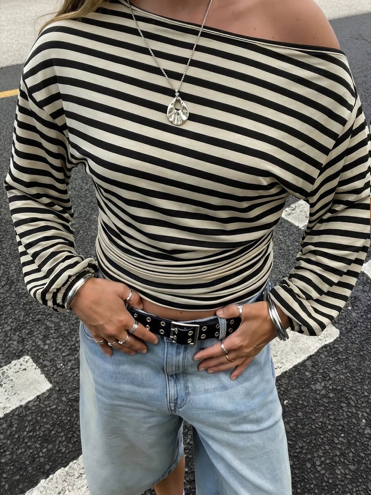 Side view of black apricot striped slim-fit long sleeve top