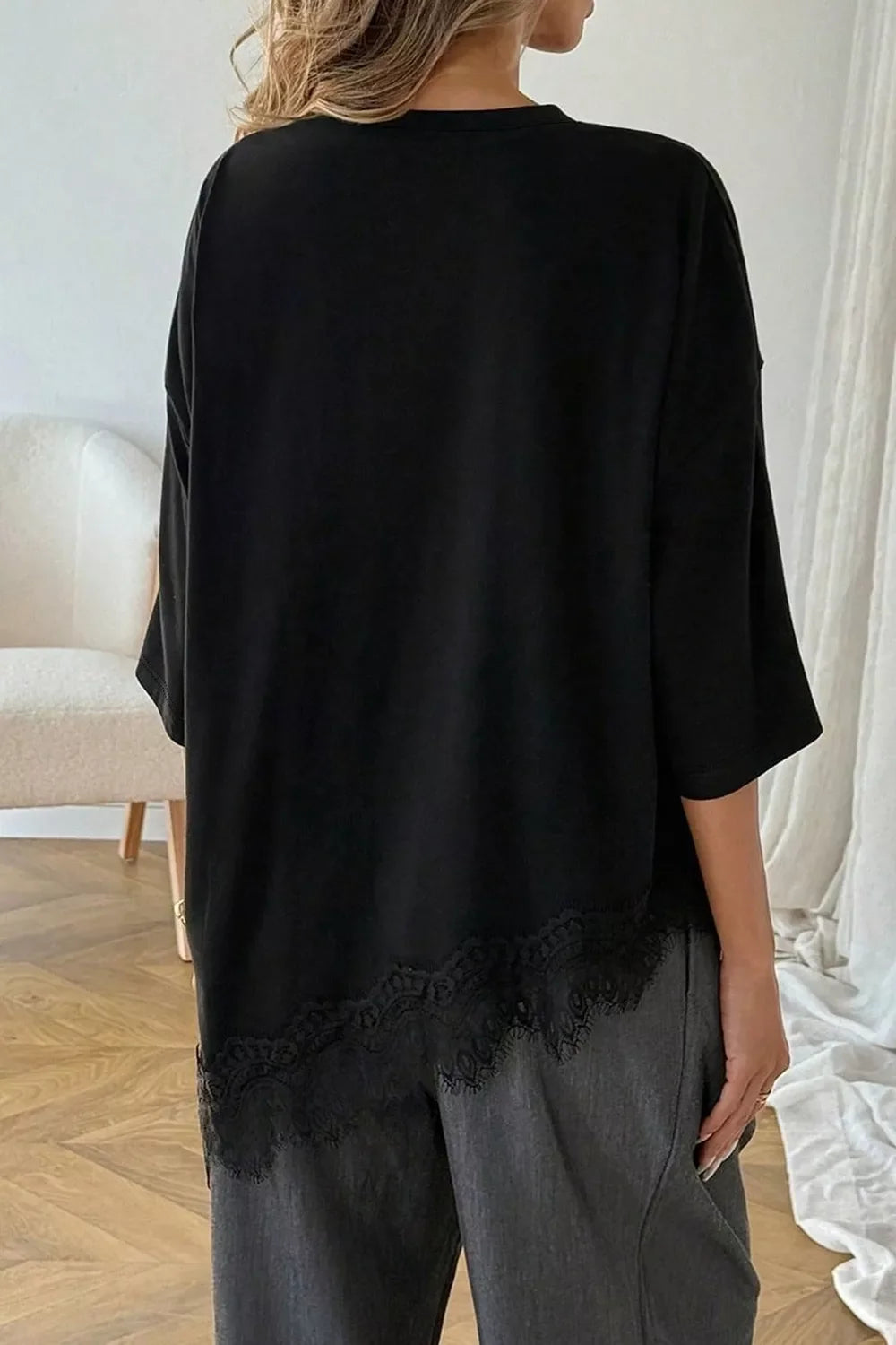 Model wearing black oversized lace hem t-shirt, styled outfit