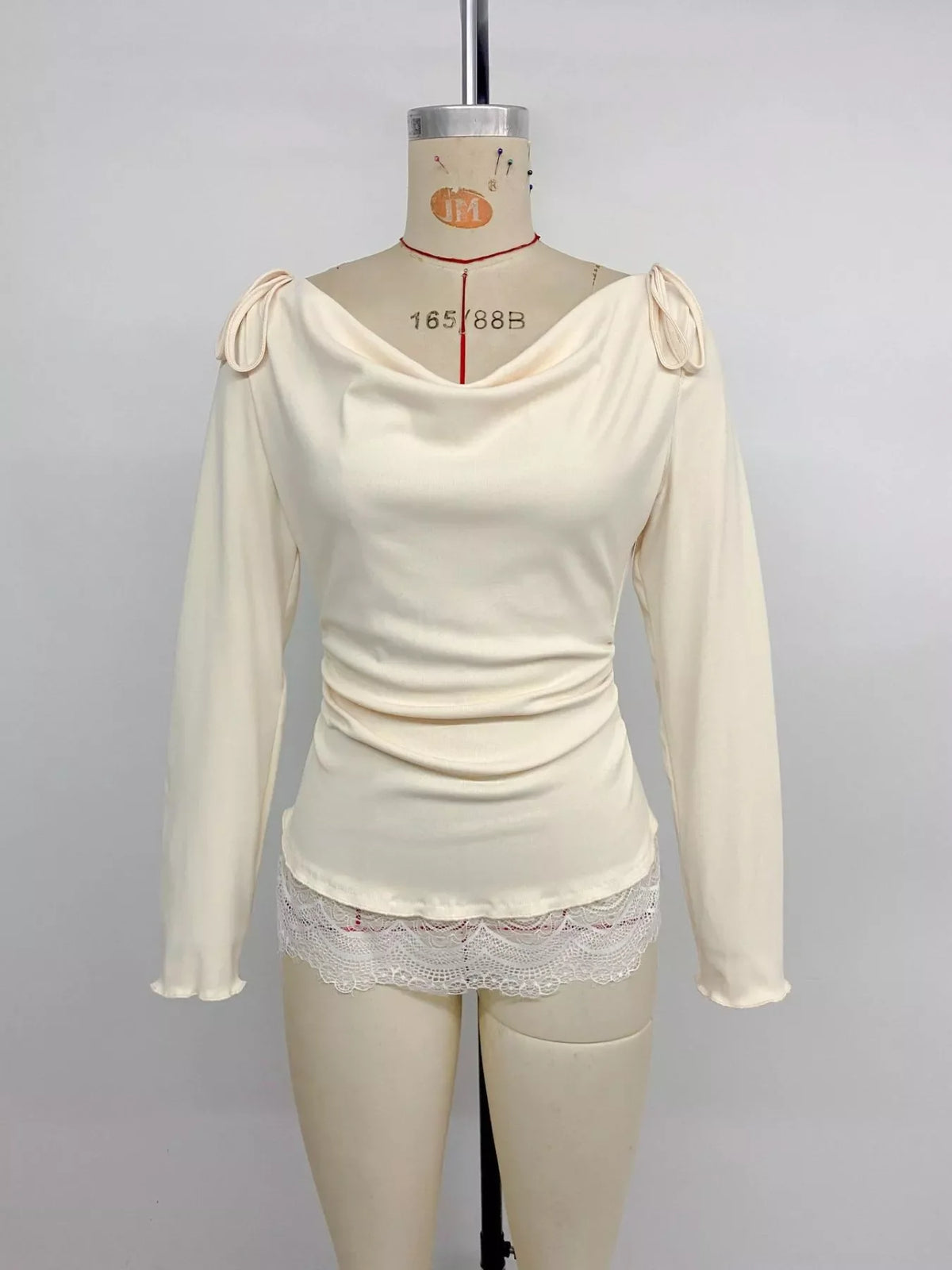 Close-up of tied detail on apricot long sleeve top