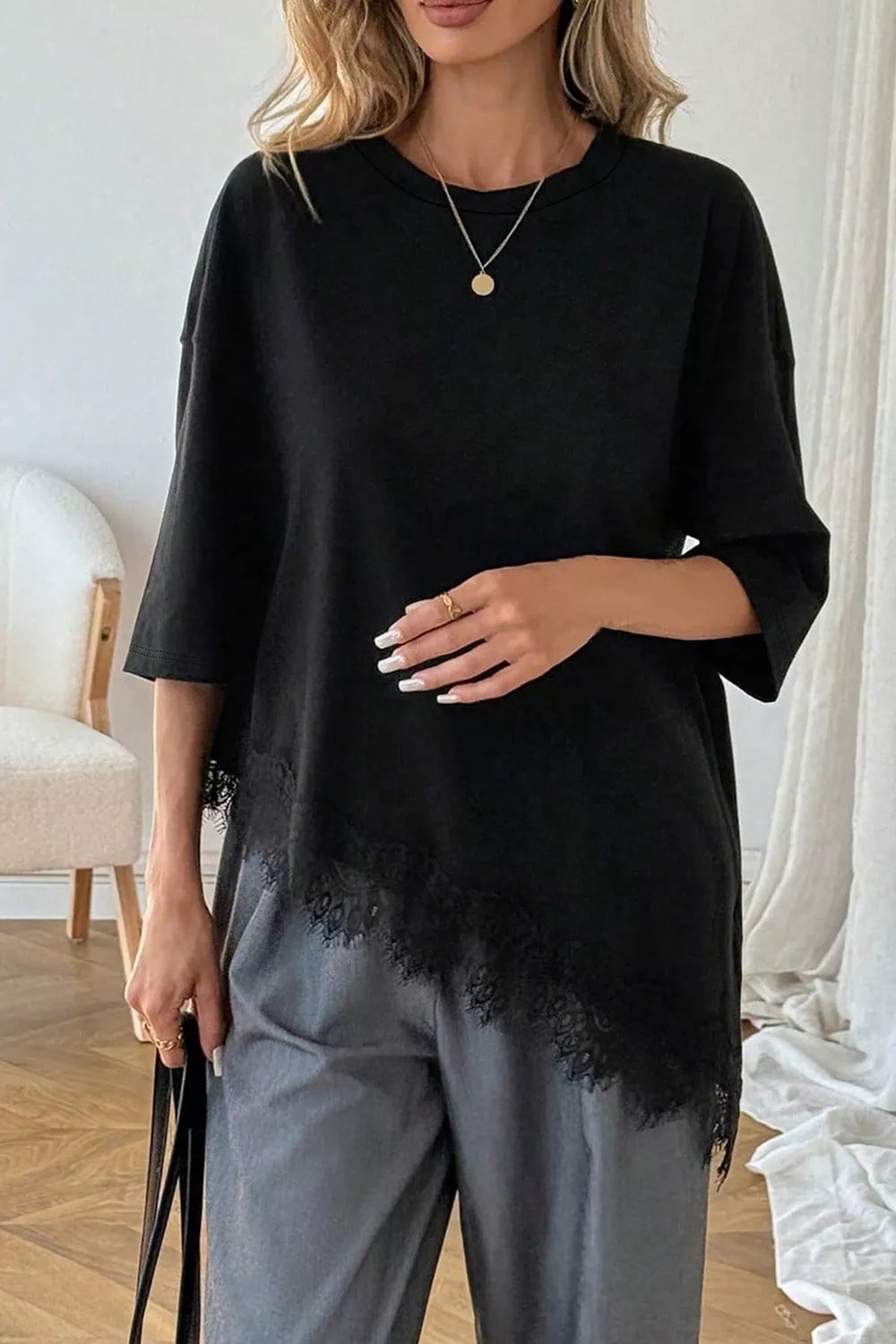 Side view of black oversized round neck t-shirt with lace hem